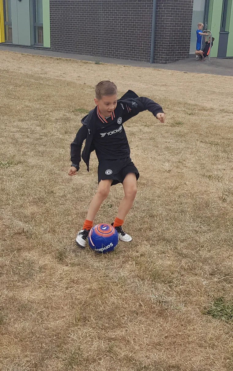 young boy kicking a football